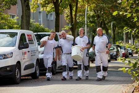 ISOTEC Team trägt Material über den Gehweg