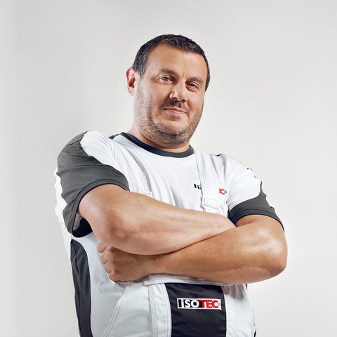 ISOTEC Mitarbeiter steht mit verschränkten Armen vor hellem Hintergrund