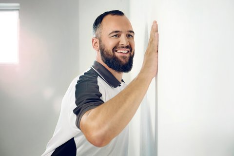 Arbeiter prüft glatte Wandfläche